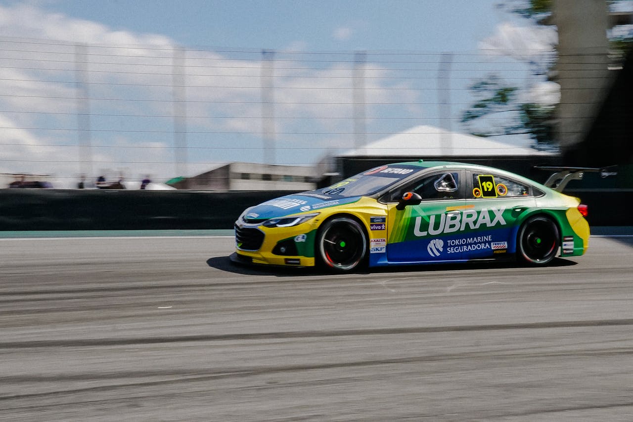 services-03 Dynamic shot of a high-speed stock car racing on a circuit, highlighting motion blur and vibrant colors.